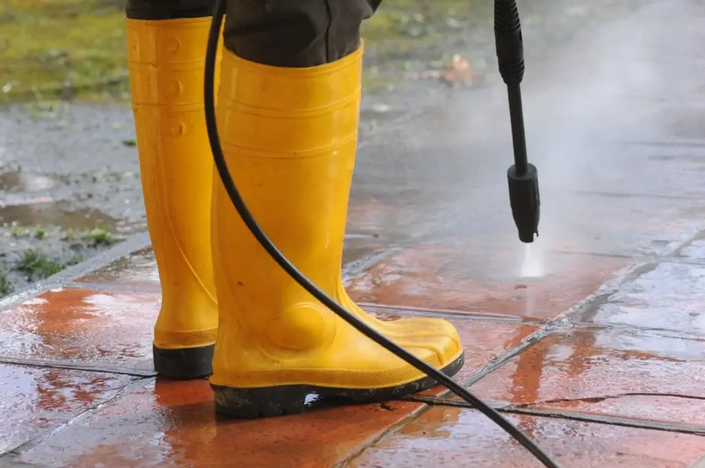 Pressure washing London paving with a high pressure water nozzle